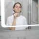 Woman using smart mirror for AI skin scan.