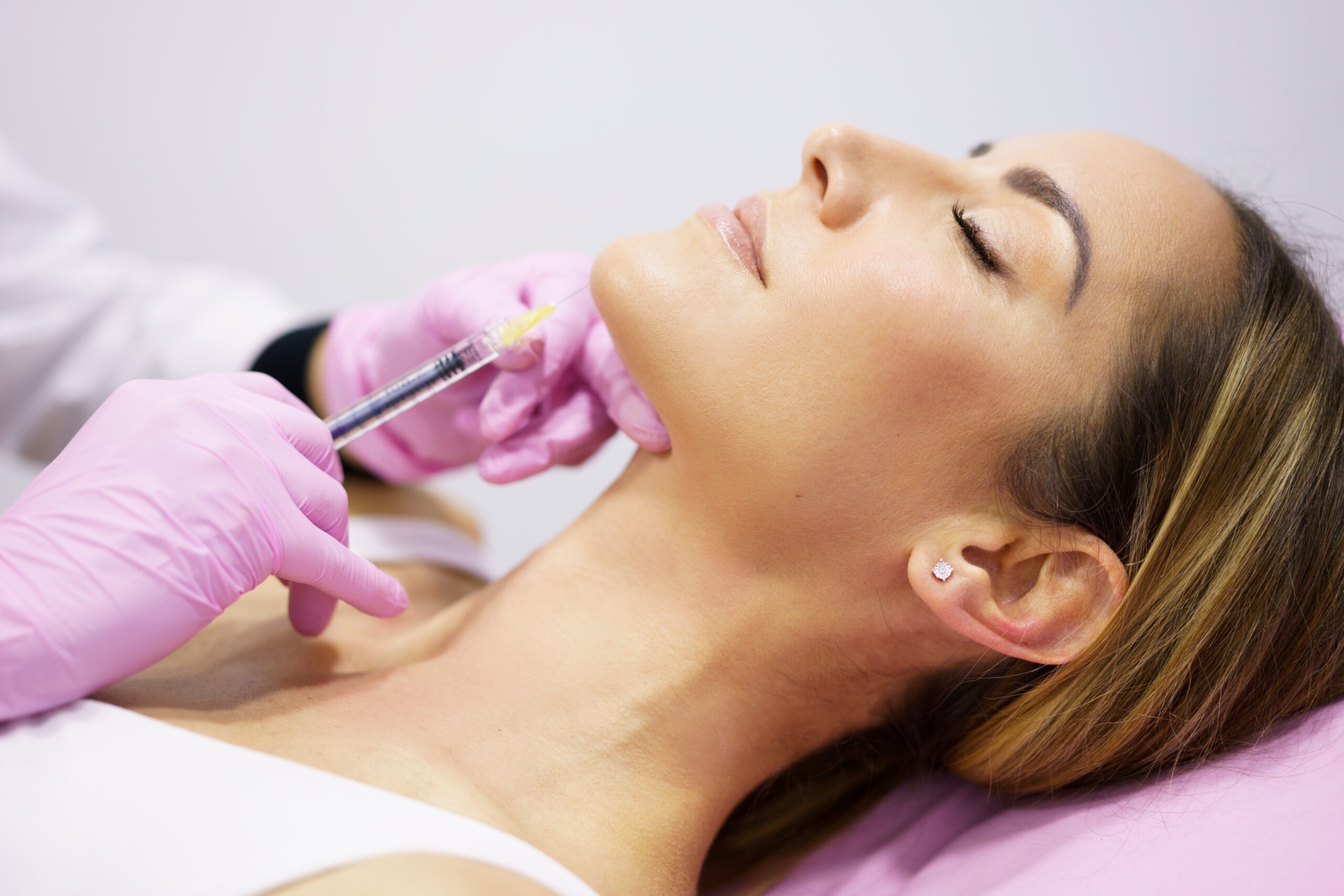Aesthetic practitioner performing jawline filler treatment