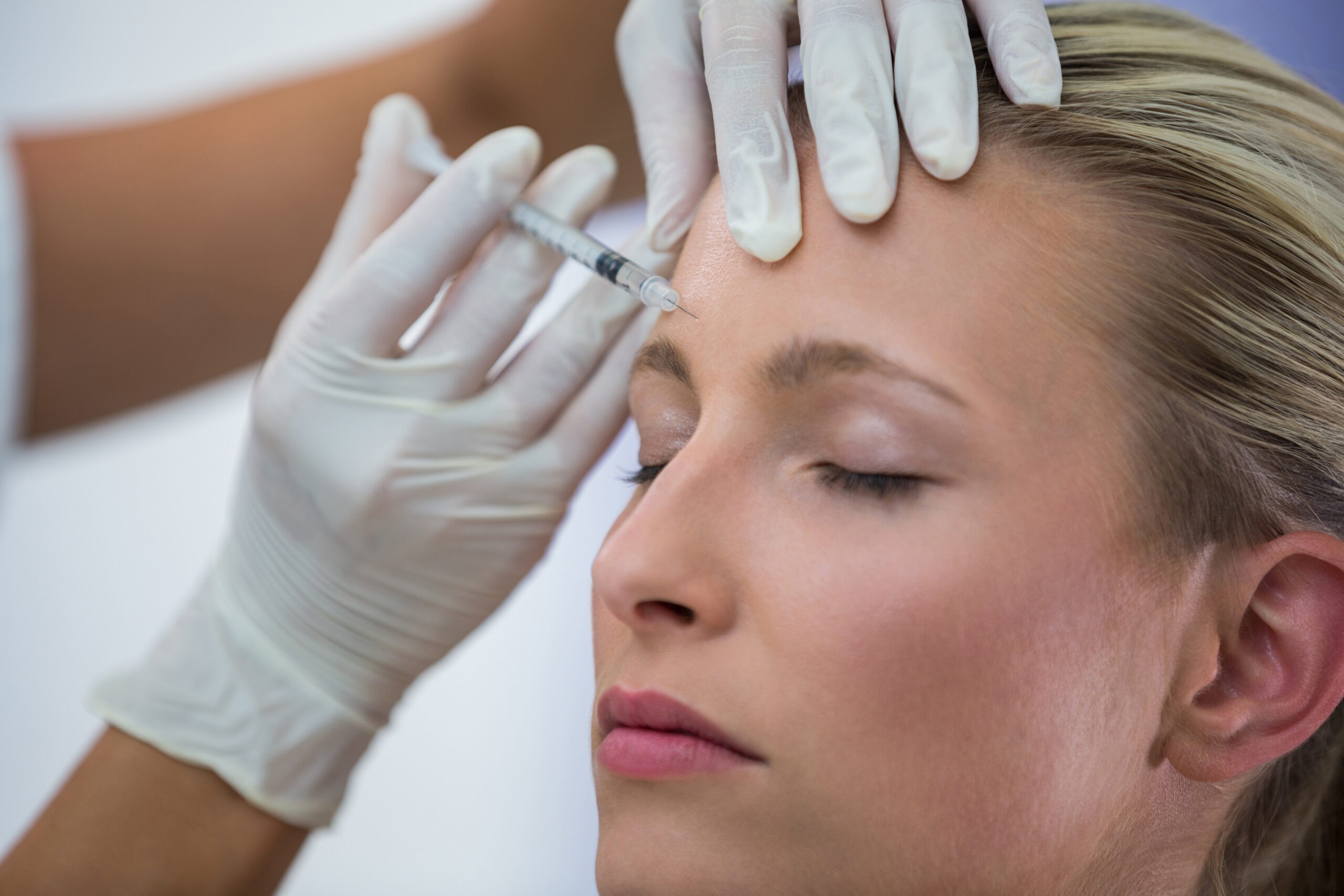 woman receiving neuromodulator injections around forehead and eyes