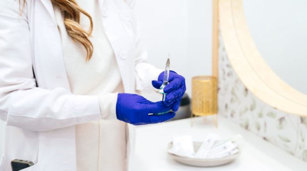 Cosmetologist preparing Radiesse filler for facial contouring at Reveal Clinics