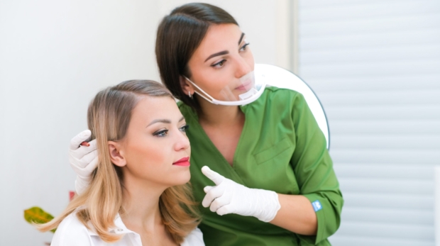 Cosmetologist consulting a patient on regenerative dermatology and exosome therapy at Reveal Clinics Riyadh.