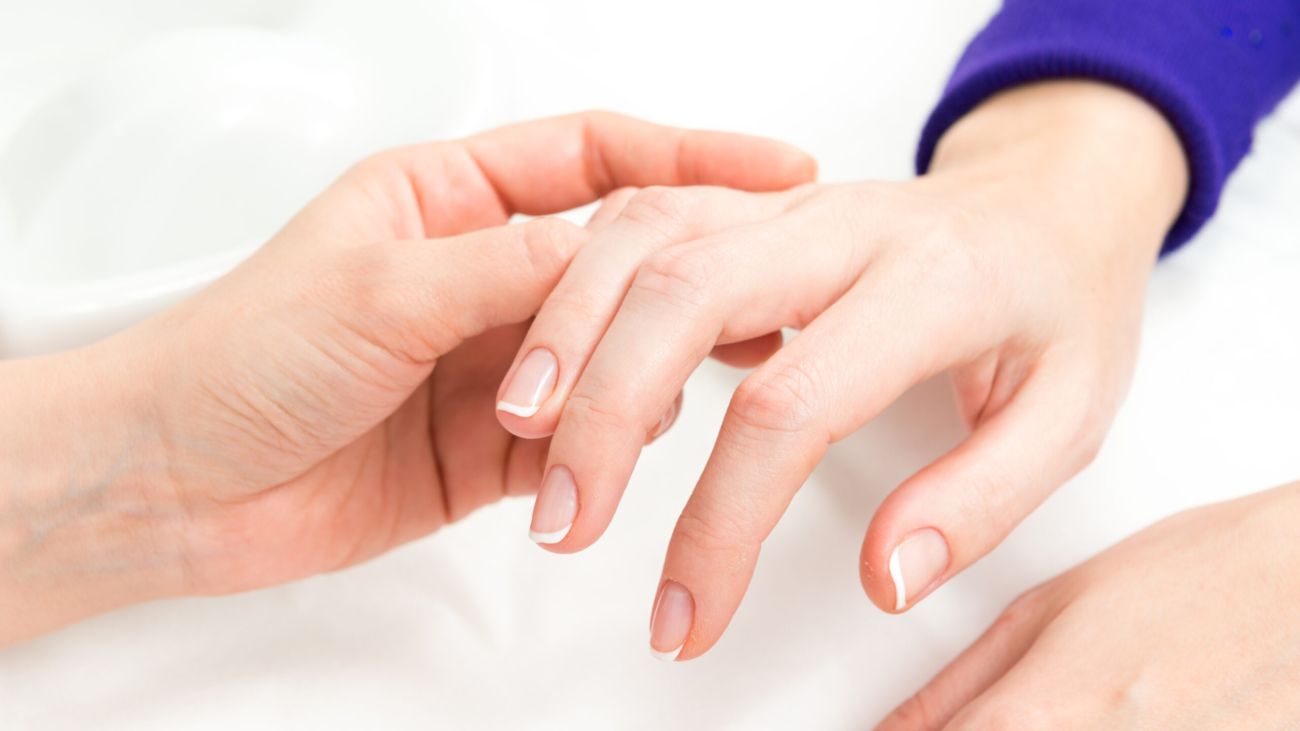 Dermatologist assessing aging hands before hand rejuvenation treatment